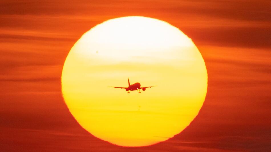 Ein Flugzeug vor untergehender Sonne