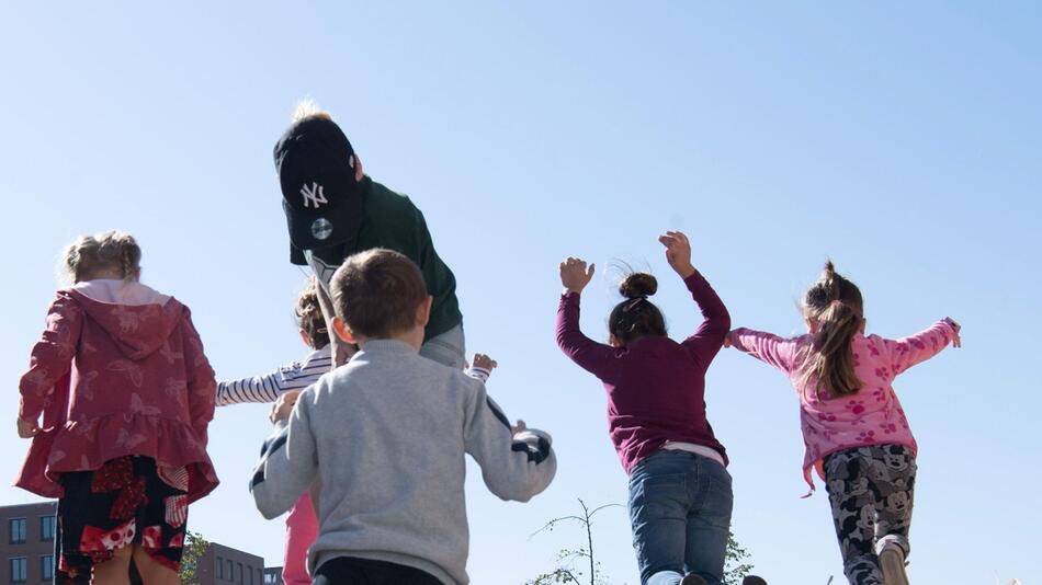 Kinder hüpfen im Heu am Weltkindertag