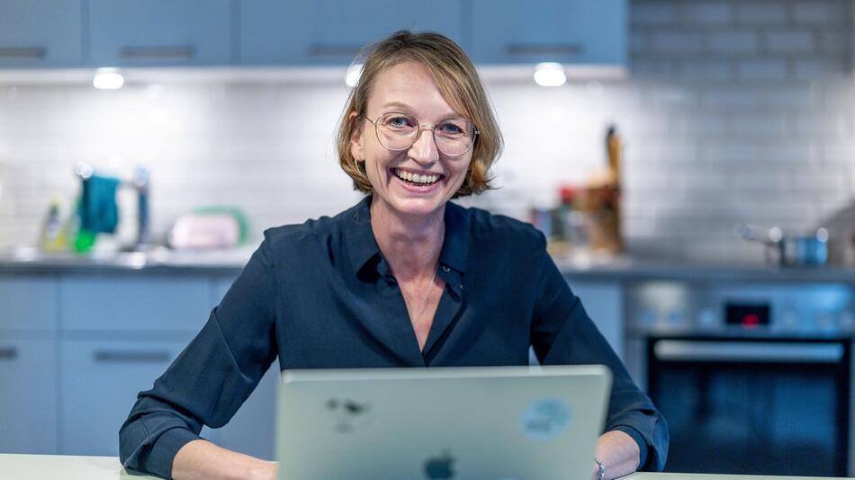 Veronique van den Borre sitzt am Küchentisch mit ihrem Laptop