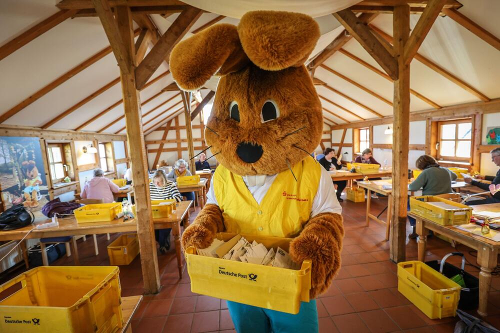 Ein als Hanni Hase verkleideter Mann im Osterhasenpostamt