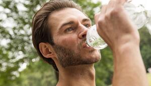 Mann trinkt Wasser aus einer PET-Flasche