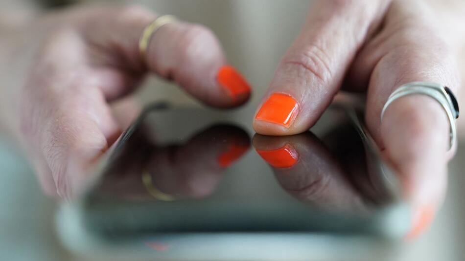 Frau tippt auf einem Smartphone