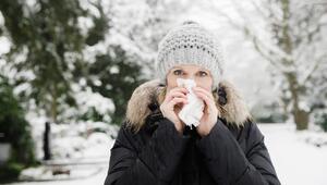 Frau im Schnee putzt sich die Nase