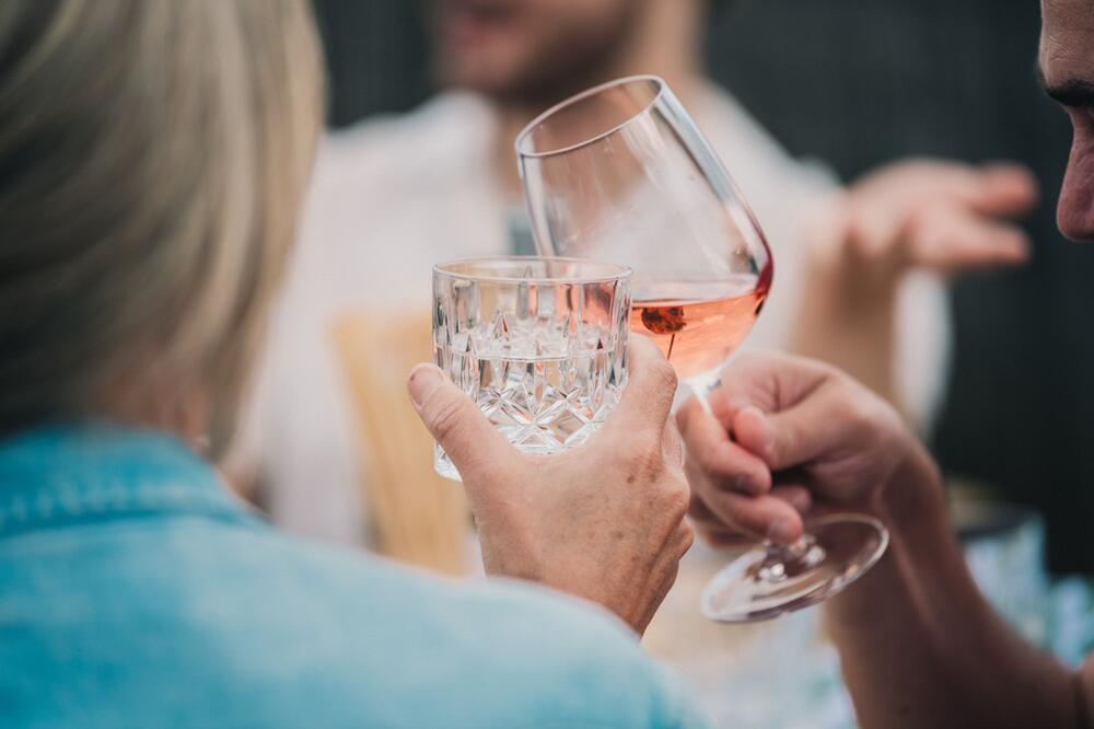 Gemeinsam anstoßen mit Wasser und Wein