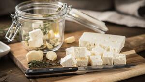 Feta mit Öl, Kräutern und Knoblauch auf einem Holzbrett