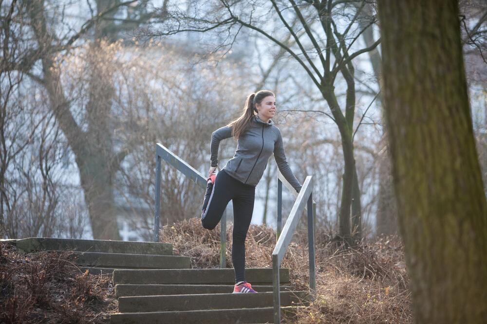 Joggerin bei Dehnübungen im Park