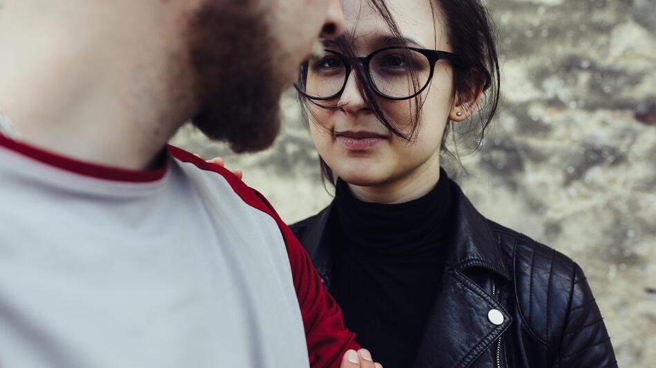 Junges Paar, sie hält ihn am Arm fest