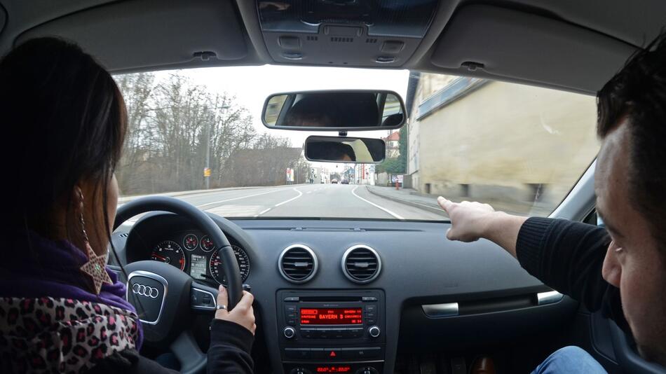 Eine Fahrschülerin sitzt in einem Auto