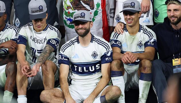 Thomas Müller grinst inmitten seiner Teamkollegen. 