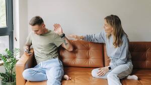 Ein Mann benutzt ein Mobiltelefon und ignoriert eine Frau, die mit ihm sprechen möchte.