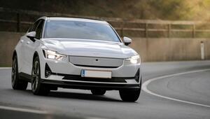 Weißes Elektroauto der Marke Polestar, frontal aufgenommen, fährt auf einer kurvigen Straße ...