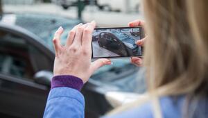 Frau fotografiert ein Auto