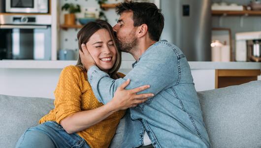 Mann küsst Frau auf den Kopf