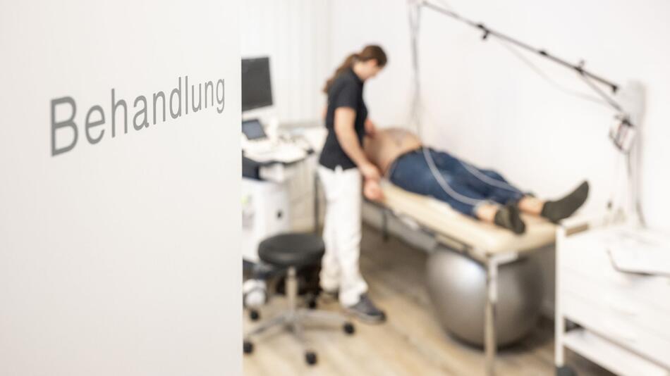 Sprechstundenhilfe bereitet Patienten auf Ruhe-EKG vor
