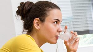 Eine Frau trinkt ein Glas Wasser