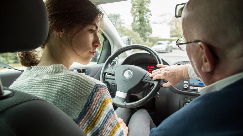 Eine Fahrschülerin mit ihrem Fahrlehrer