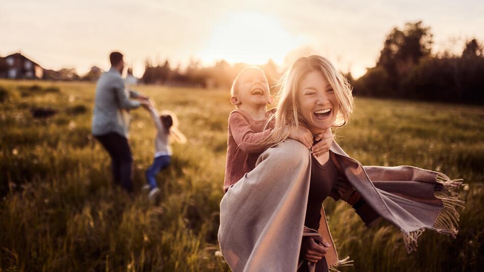 Familie tanzt ausgelassen in der Natur