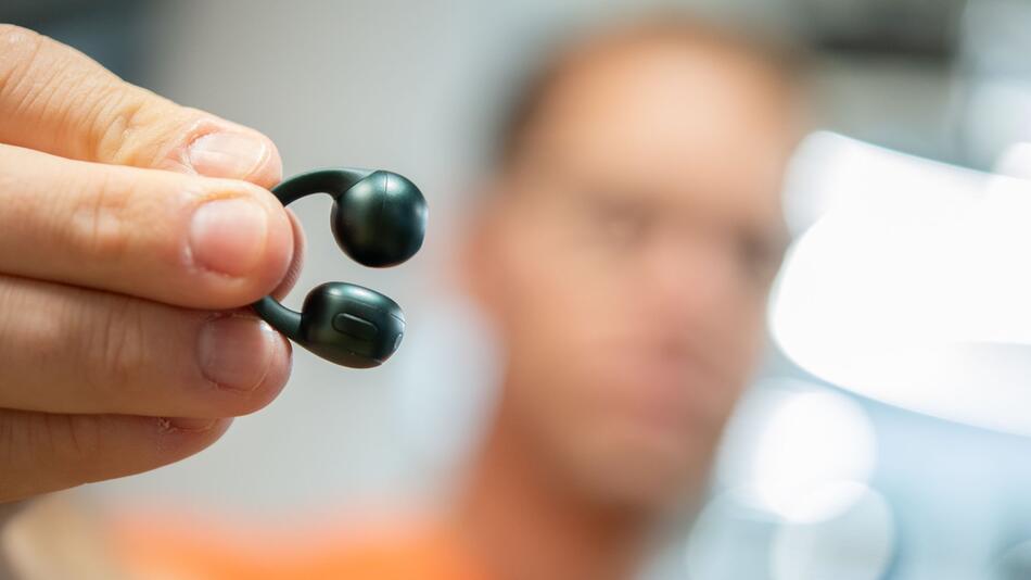 Mann hält die Moto Buds Loop von Motorola in der Hand