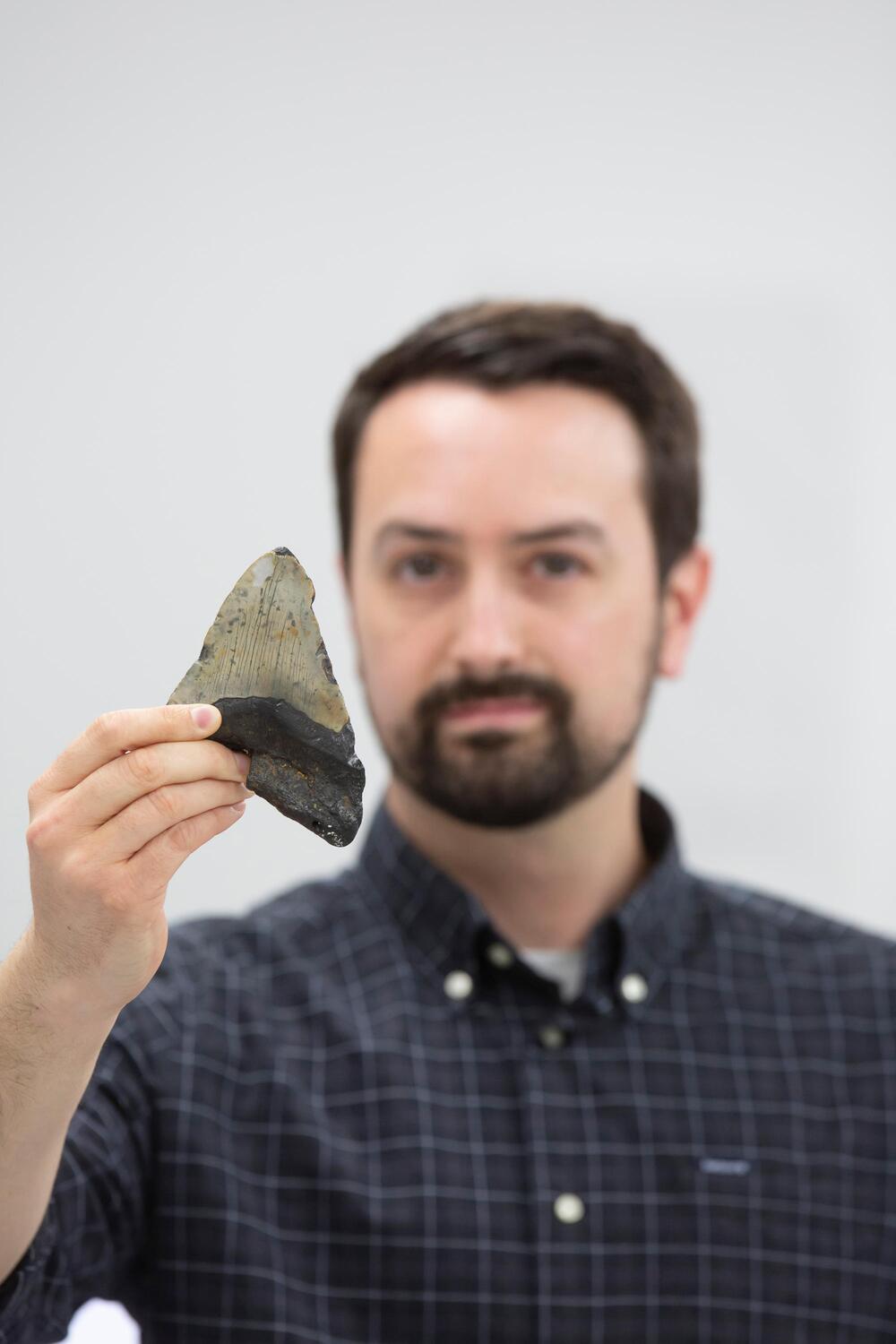 Dr. Jeremy McCormack mit einem versteinerten Megalodon-Zahn