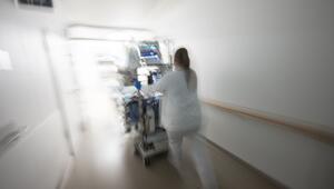 Pflegerin fährt eine Intensivpatientin durch denGang einer Klinik