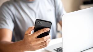 Mann mit Smartphone und Laptop