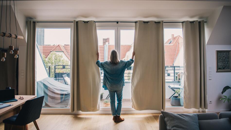 Eine Frau schleißt Gardinen