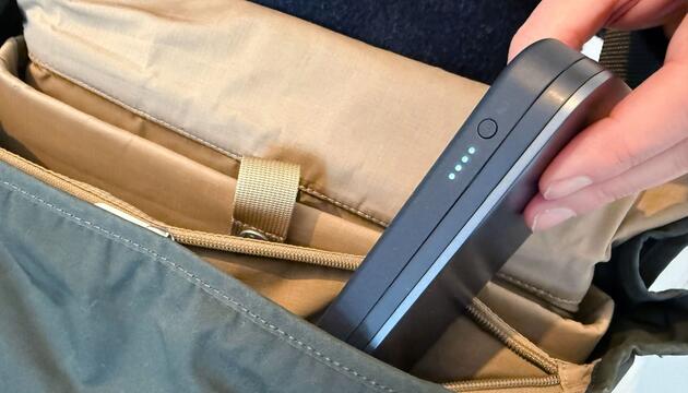 Mann steckt eine Powerbank in seinen Rucksack