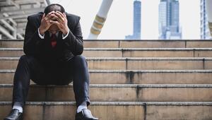 Geschäftsmann sitzt gestresst vor dem Büro