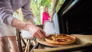 Ein Mann holt eine Pizza aus dem Ofen