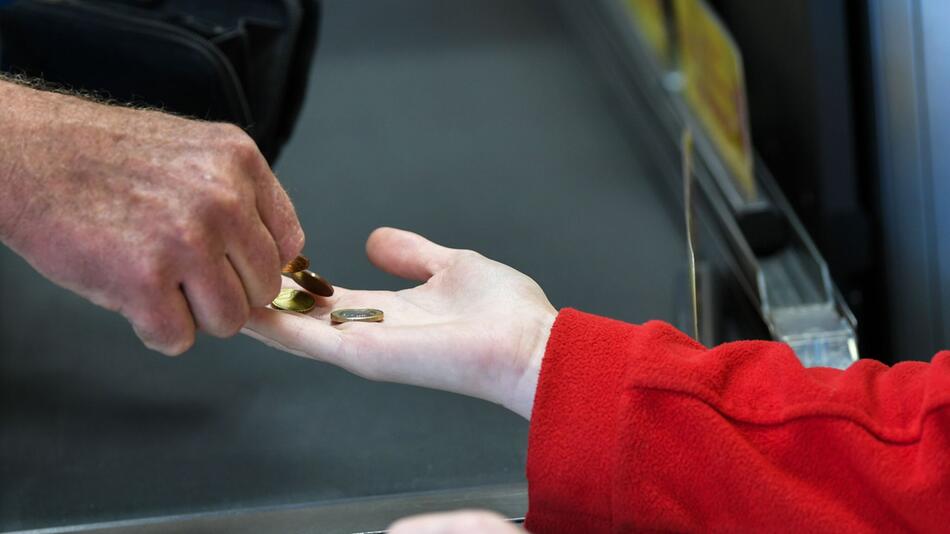 Eine Kassiererin in einem Supermarkt nimmt Geld entgegen