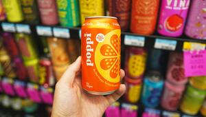 Hand hält einen Functional Drink: eine orangefarbene Dose "poppi" mit Orangen-Geschmack, im ...