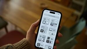 Ein Mann hält ein iPhone mit schwarz-weißem Display in der Hand
