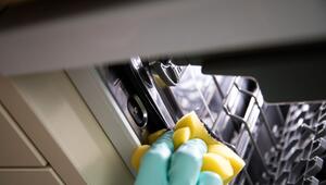 Eine Frau reinigt einen Geschirspüler