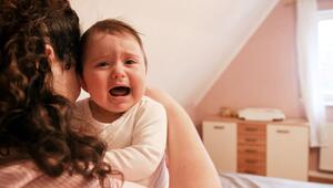 Eine junge Frau tröstet ihr weinendes Baby