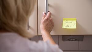Eine Frau hat Zettel als Erinnerung in die Küche geklebt