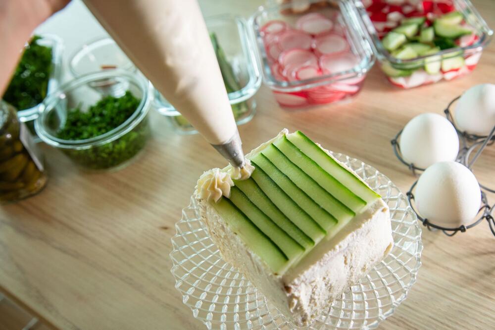 Brottorte wird mit Frischkäse und Gurke dekoriert