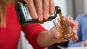 Frau schenkt ein Glas Schnaps ein