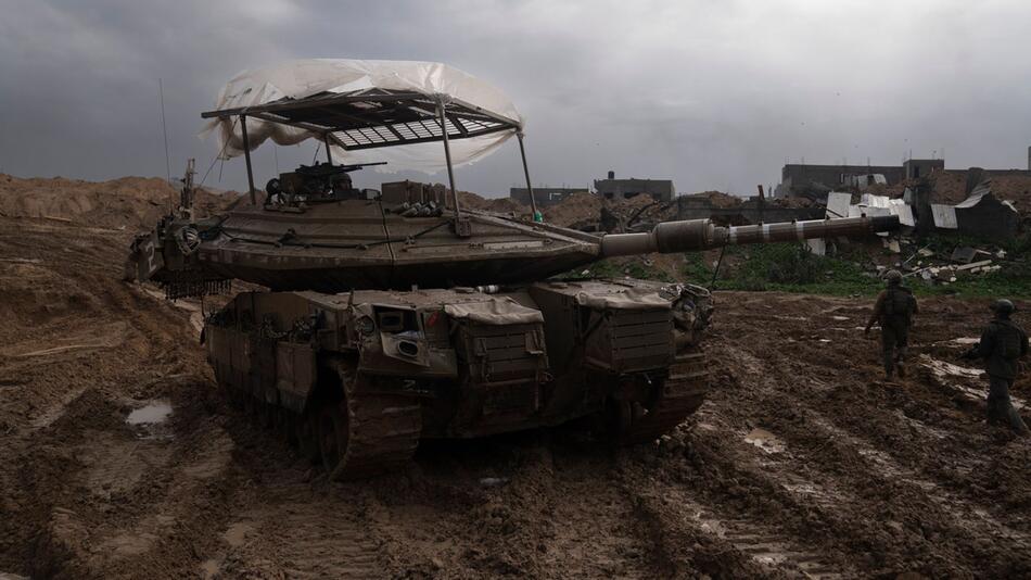 Israelische Soldaten gehen während der Bodenoffensive im Gazastreifen an einem Panzer vorbei.