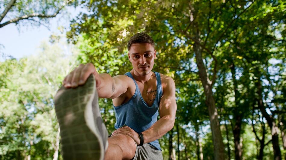 Sportler dehnt sich im Park