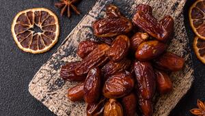 Ein Haufen Datteln. Daneben etwas Sternanis und getrocknete Orangenscheiben.