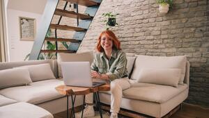 Eine Frau am Laptop sitzt auf einem Sofa