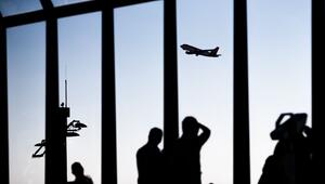 Passagiere schauen am Flughafen einem startenden Flugzeug zu