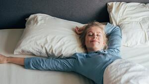 Frau liegt lächelnd im Bett