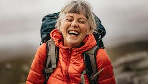 Ältere Frau beim Wandern, die sehr glücklich ist. 