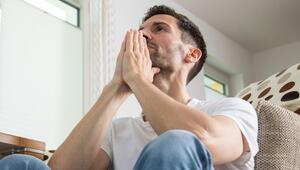 Mann sitzt nachdenklich im Wohnzimmer