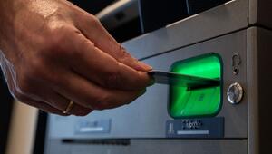 Mann gibt Karte in einen Bankautomaten