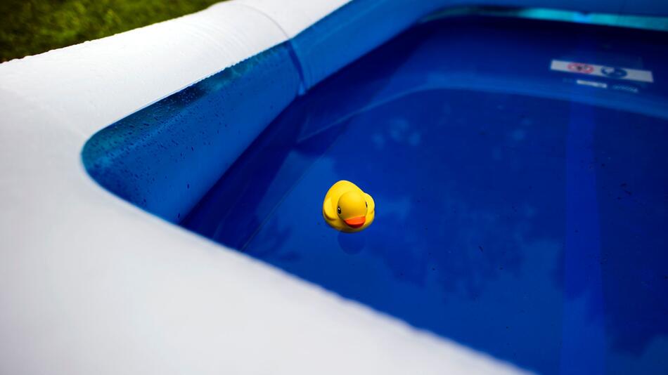 Eine gelbe Plastik-Ente schwimmt in einem Pool