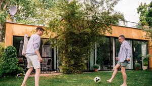 Zwei Männer spielen Fußball im Garten eines Hauses
