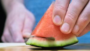 Mann schneidet eine Wassermelone