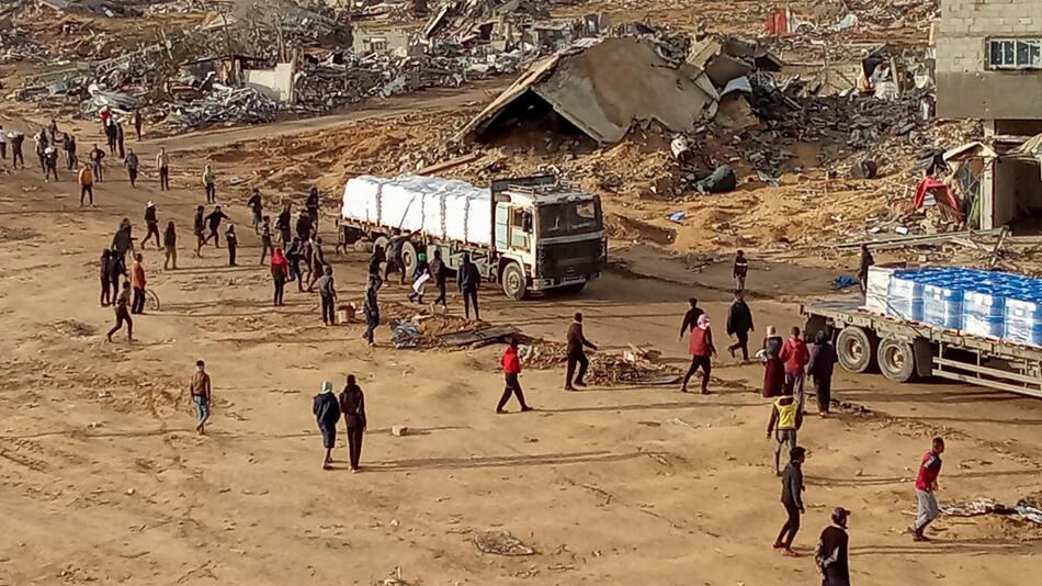 Palestinians attempt to grab aid from a truck, following a ceasefire between Israel and Hamas